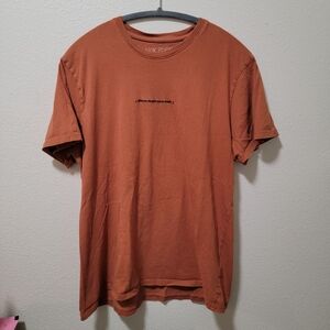 Men's Rust Color Shirt That Says "[Sinister Background Music]